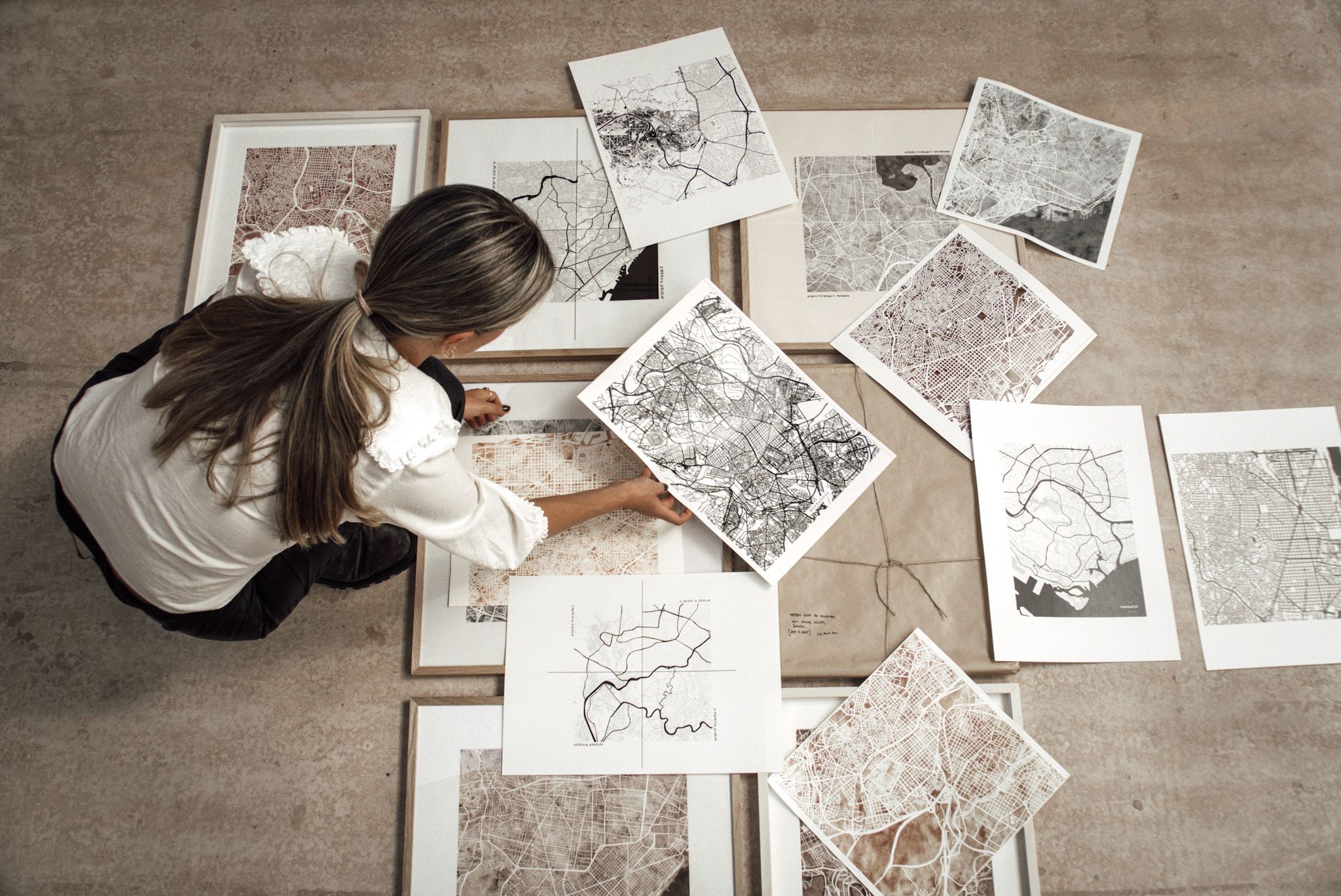 Artista eligiendo mapas para enmarcar en cuadros